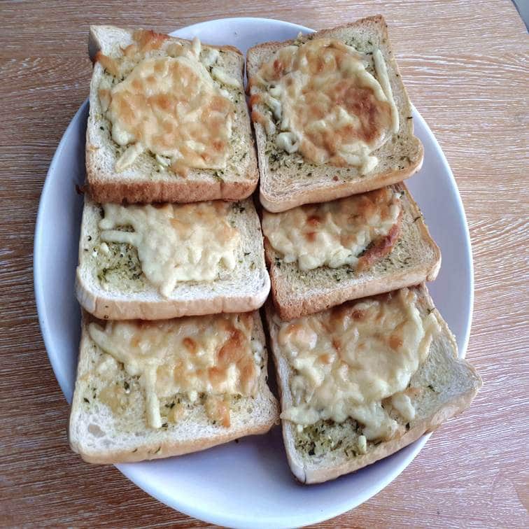 garlic bread using sliced white bread topped with cheeses served on a plate 