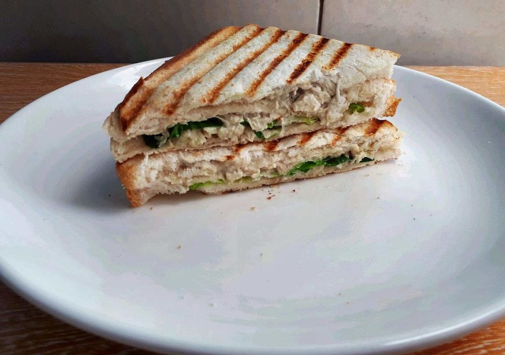 A Filipino style chicken sandwich spread   served on a plate