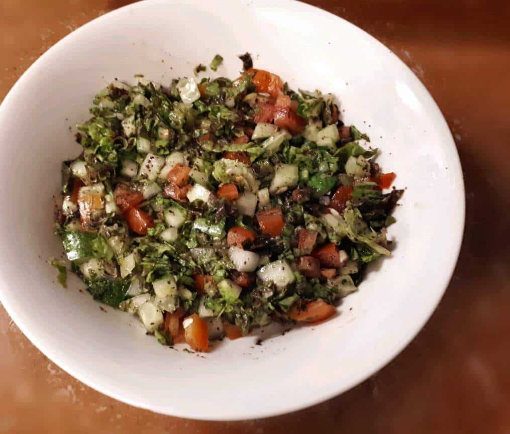 Arabic Salad Recipe mixed with cucumber, tomatoes, lettuce and parsley in a large bowl