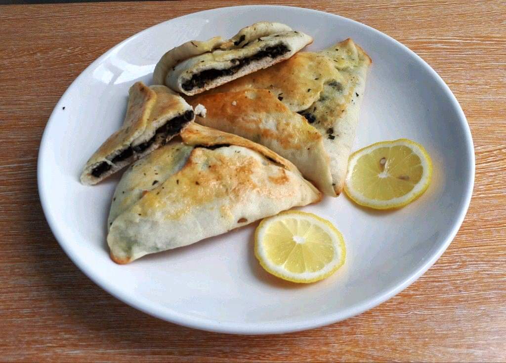 Sabanekh Spinach Fatayer Recipe serve with slices of lemon in a plate