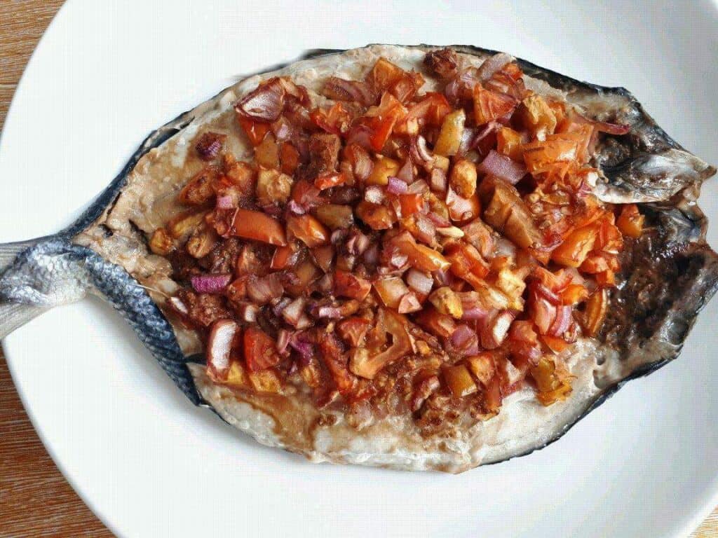 Baked Bangus (Milkfish) topped with ginger, tomatoes and red onion.