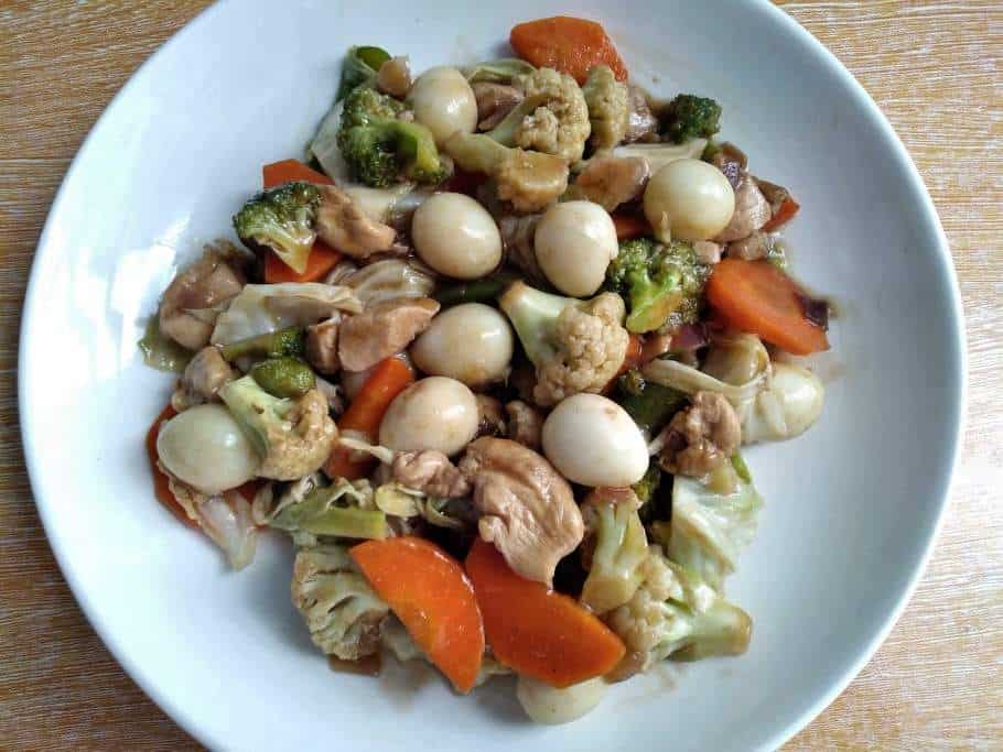 A Filipino Chop suey mixed with chopped chicken, carrot, cauliflower, broccoli, quail egg and cabbage serve in a plate