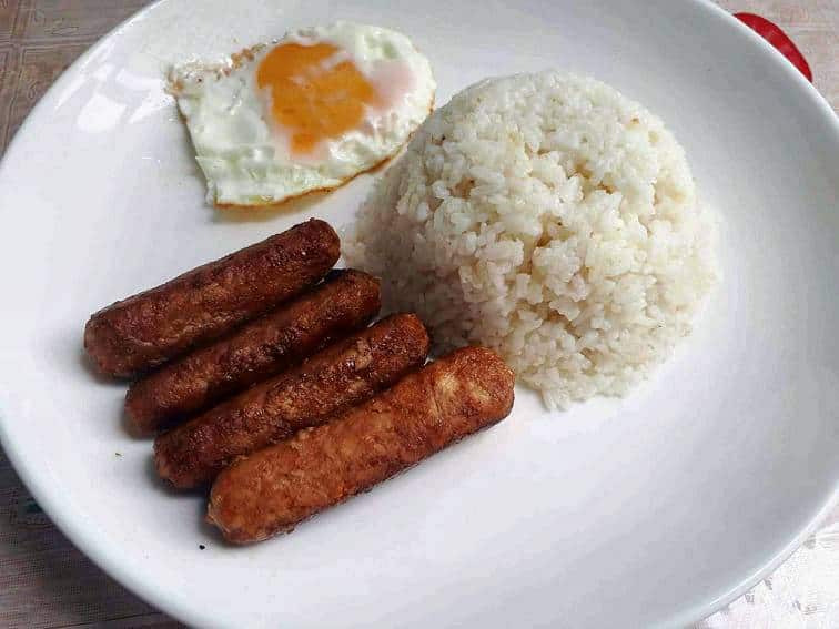 Chicken Longganisa serve with garlic white rice and fried sunny side up egg in a plate