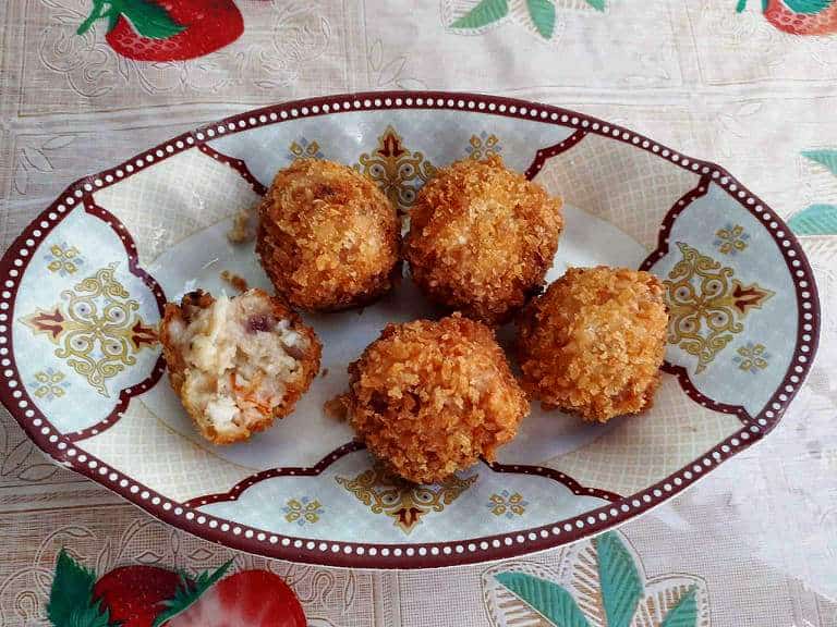 a deep fried Shrimp Croquettes in a ball shaped serve in a plate