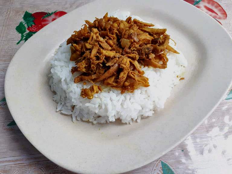 Chicken Pastil Recipe made with white steamed rice topped with dry shredded chicken serve in a plate.