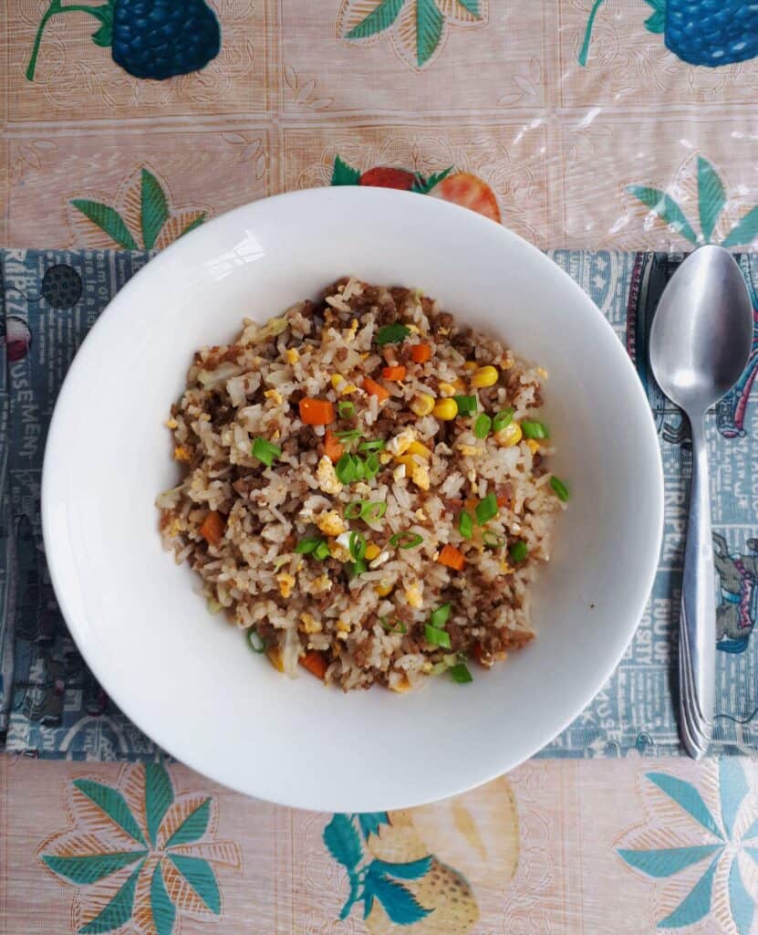 Beef Chao Fan recipe mixed with ground beef, carrots, cabbages, spring onion, eggs and rice serve on a plate bowl.