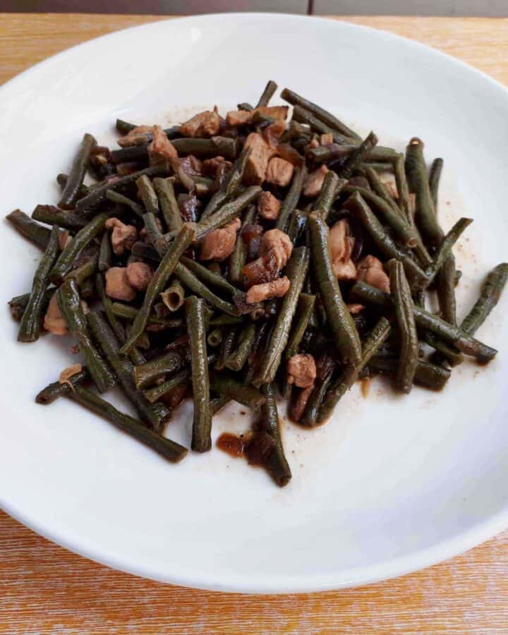 Adobong Sitaw green bean recipe mixed with chopped boneless chicken breast on a plate