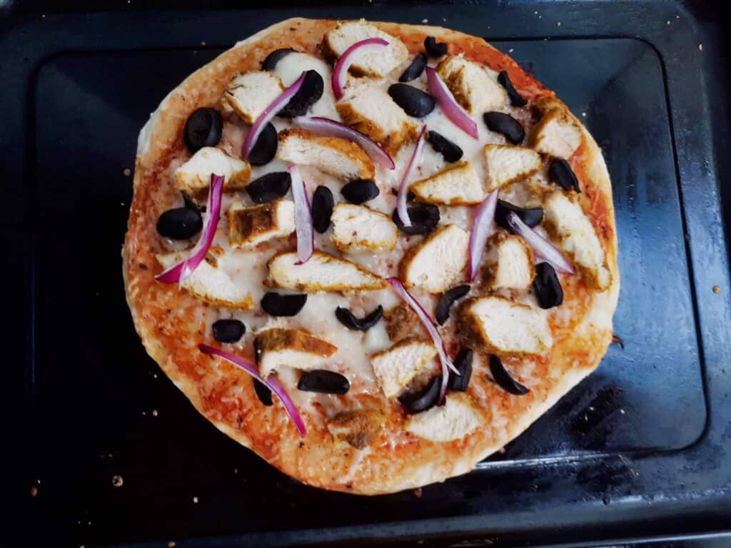Chicken Shawarma Pizza Recipe with sliced chicken breast, black olives,  and red onion serve on a tray