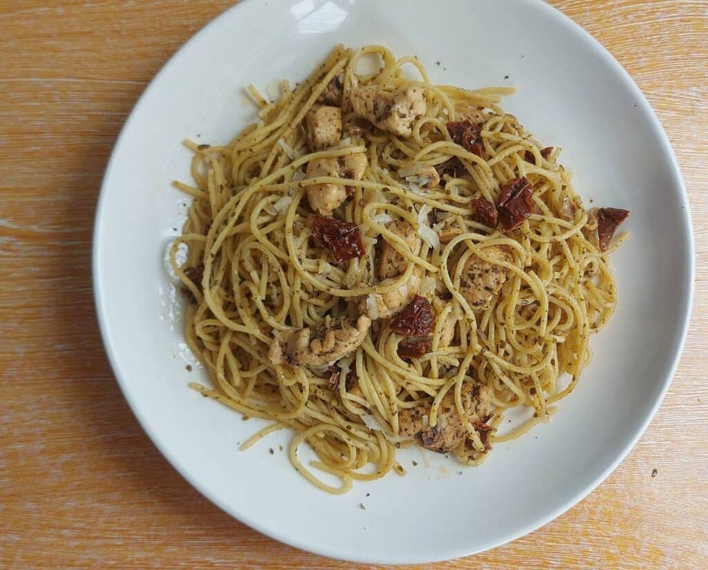 Chicken Pesto Pasta with Sun Dried Tomatoes recipe using spaghetti noodle served on a plate
