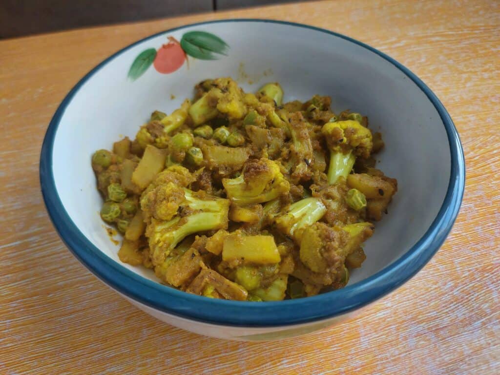 Indian Cauliflower Potato and Green Pea Curry called Aloo Gobi Matar served on a plate bowl 