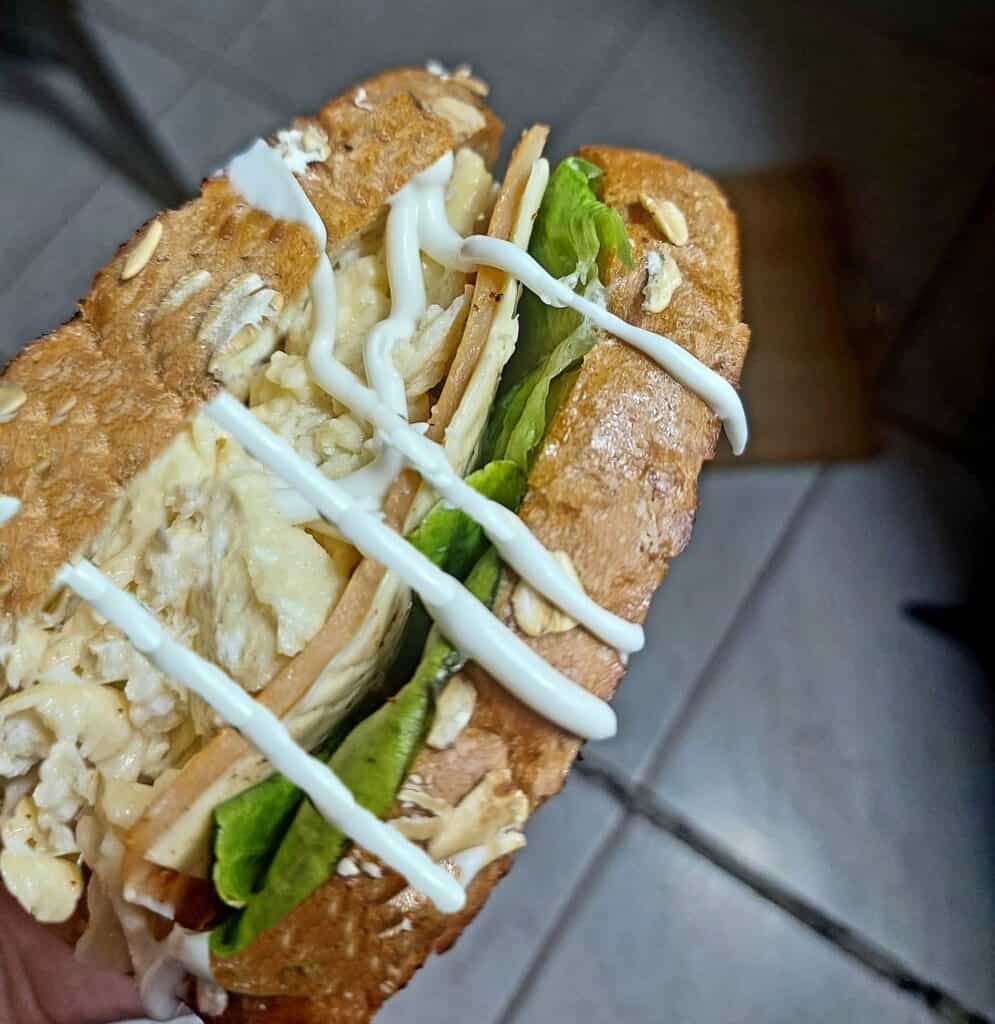 Korean Egg Drop Sandwich with fillings of scrambled egg, ham, cheese, lettuce and drizzle with sweet mayonnaise sauce served on a butter toasted bread