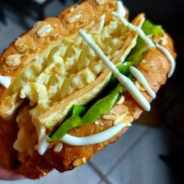 Korean Egg Drop Sandwich with fillings of scrambled egg, ham, cheese, lettuce and drizzle with sweet mayonnaise sauce served on a butter toasted bread