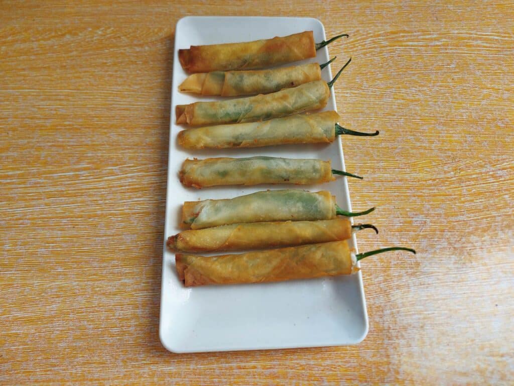 A Filipino Chili Cheese Stick Dynamite lumpia served with mayo-ketchup sauce on a plate