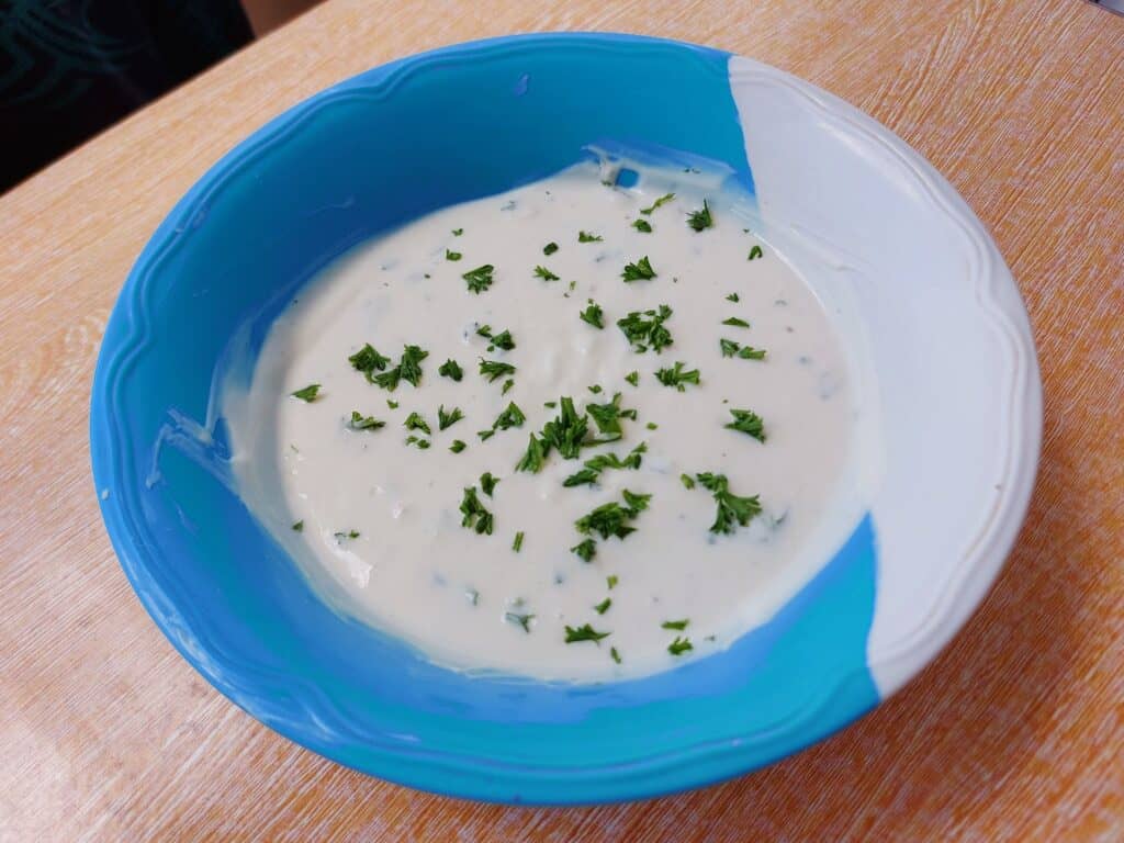  Yogurt Garlic sauce sprinkled with chopped parsley on a plate bowl best for Shawarma, Kebab or Salad dressing