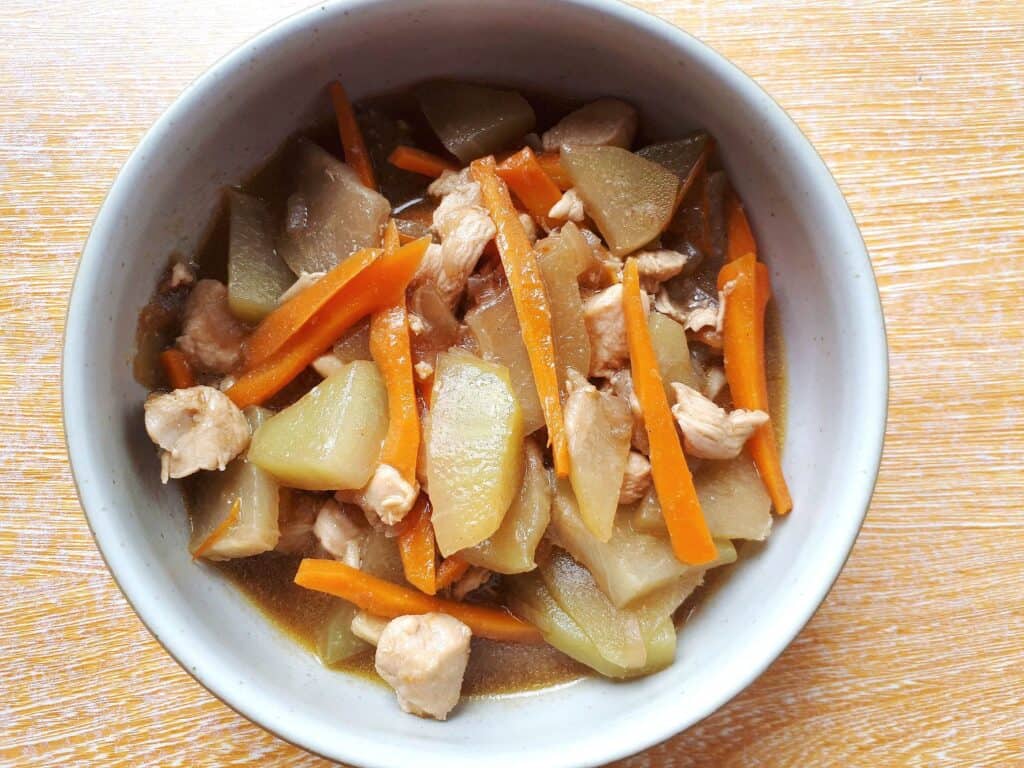 Filipino Chayote recipe Ginisang Sayote  with julienned carrot and chopped chicken breast served on a plate bowl