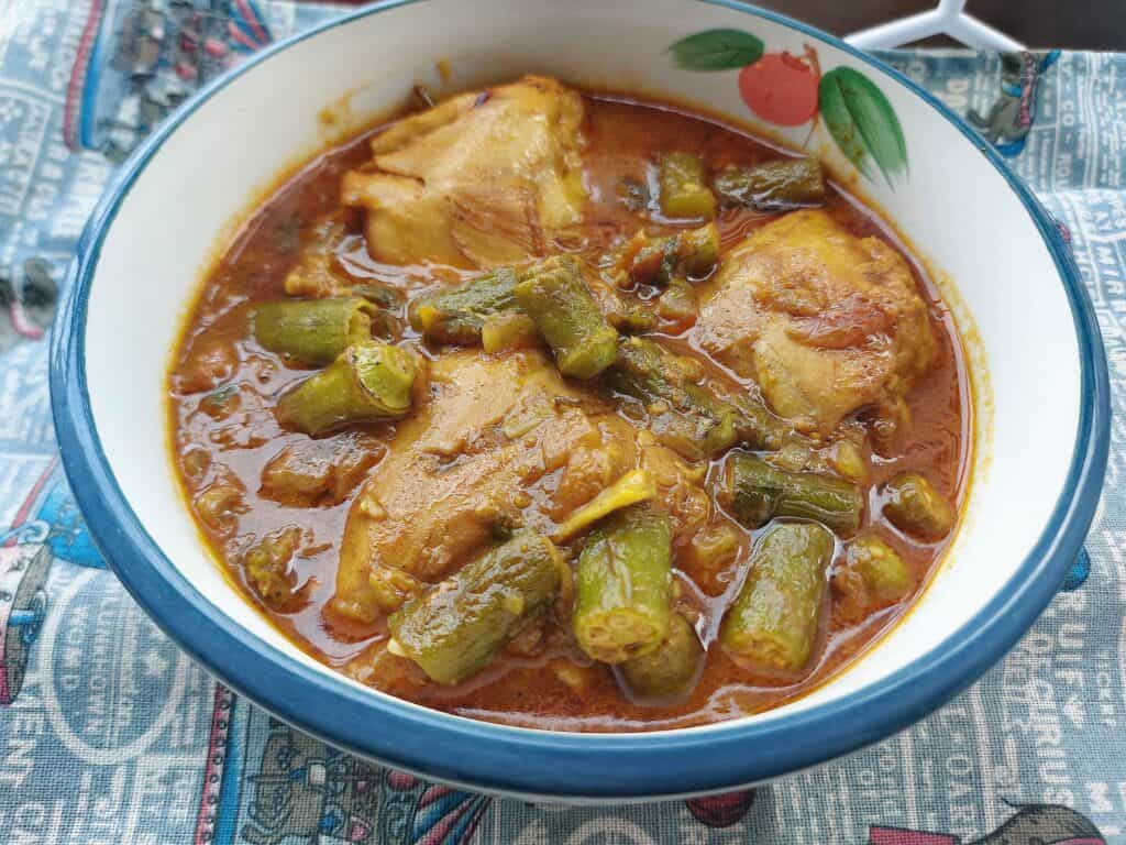 Chicken Bhindi with okra, chicken thigh, tomato gravy sauce serve on a plate bowl. 