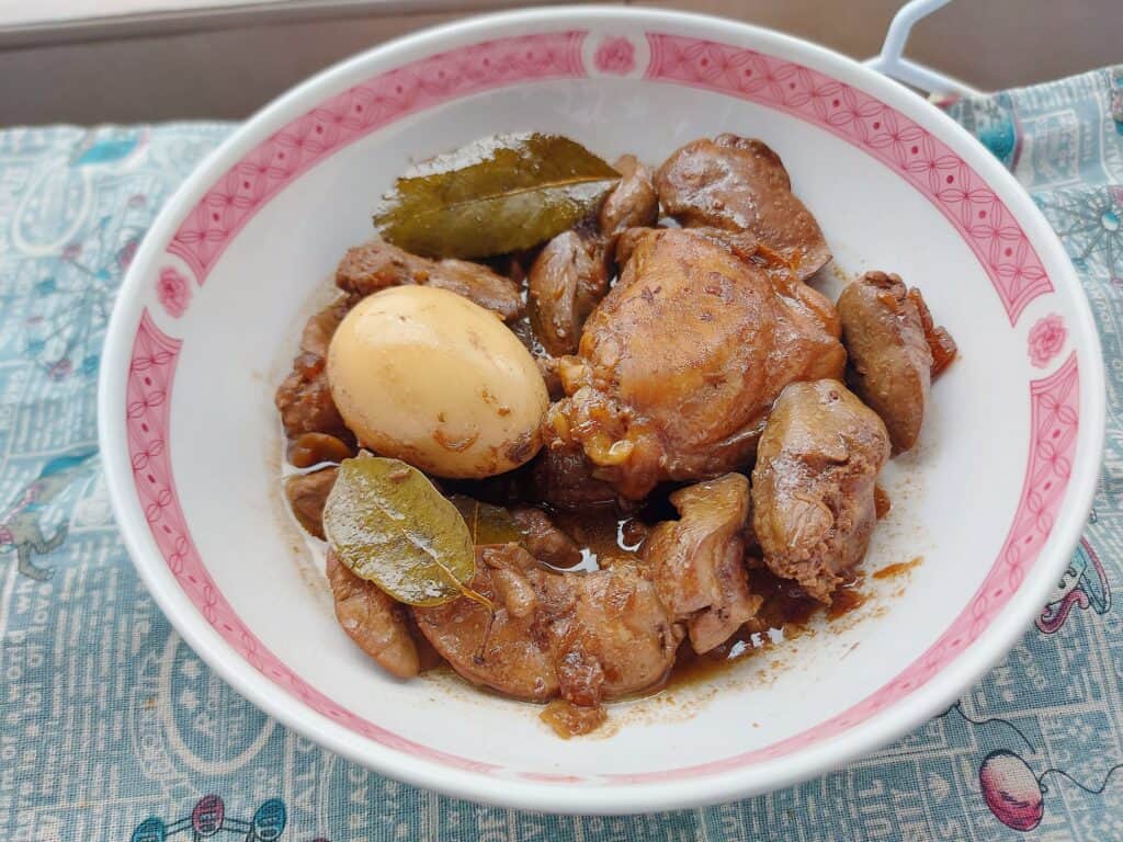 Chicken Liver Adobo recipe called Adobong Atay serve with chicken thigh, boiled egg and liver with bay leaves served on a plate bowl.