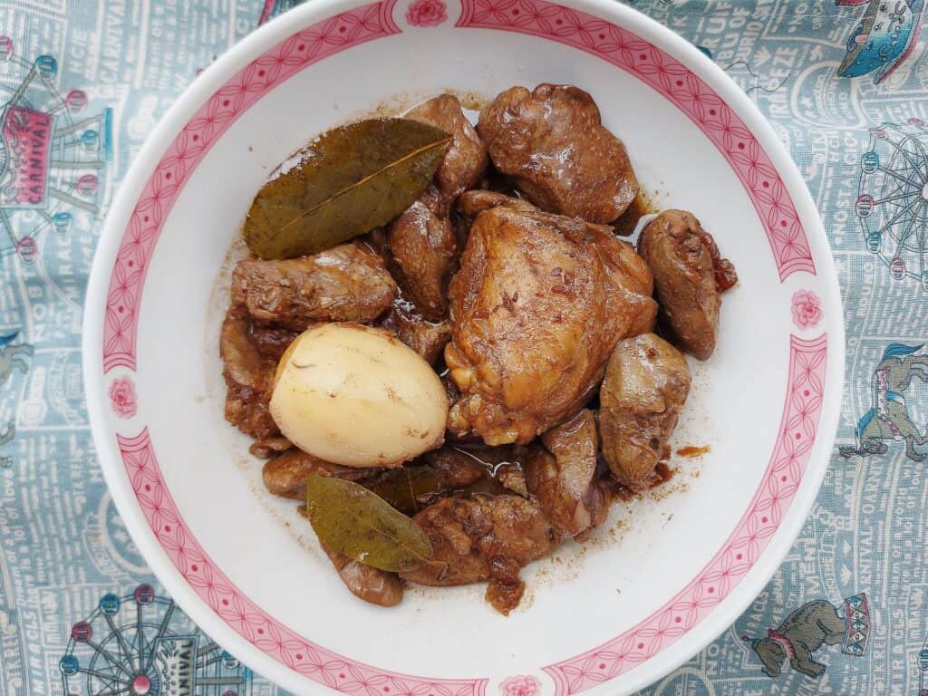 Chicken Liver Adobo recipe called Adobong Atay serve with chicken thigh, boiled egg and liver with bay leaves served on a plate bowl.