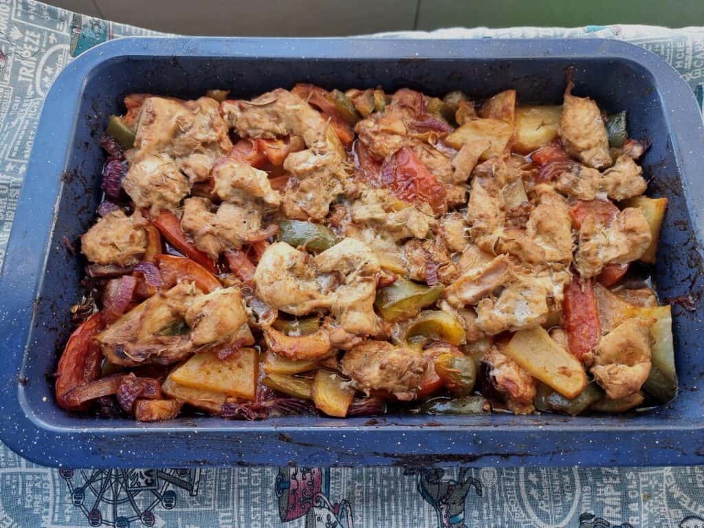 Turkish Chicken Tava (Tavuk Tava) mixed with potatoes, bell pepper, tomatoes, marinated chicken and different herbs & spices served on a baking tray