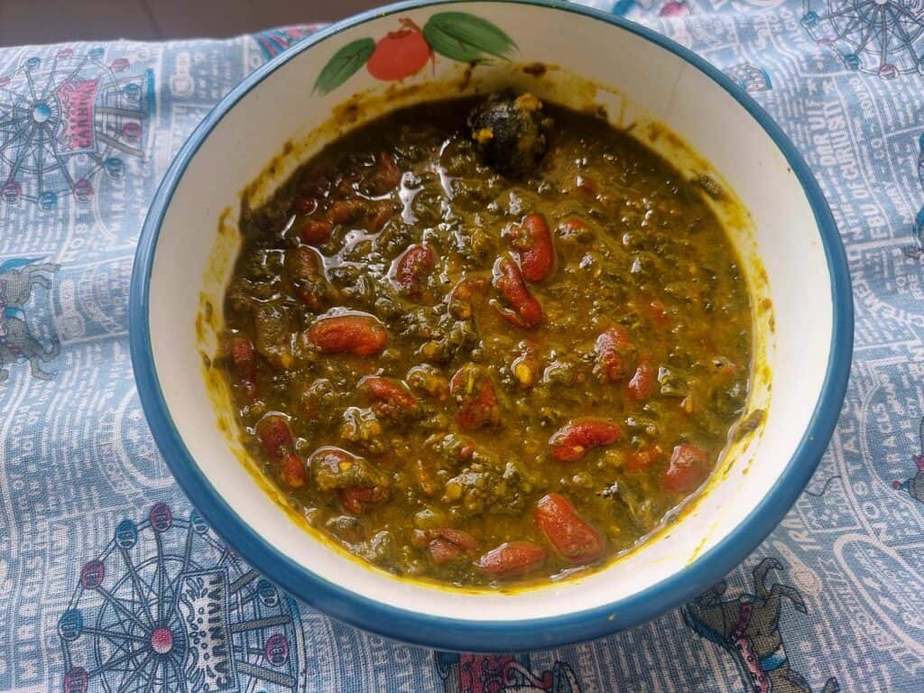 Iranian stew Ghormeh Sabzi recipe mixed with different herbs, kidney beams, dried lime and other spices served in a plate bowl