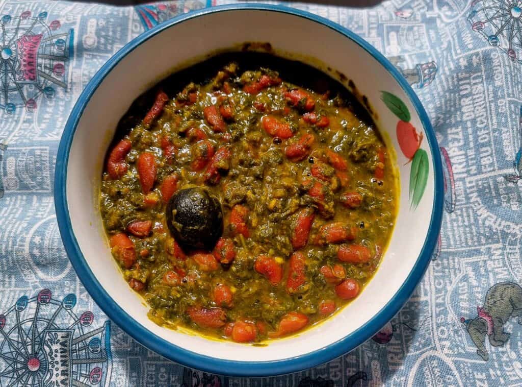 Iranian stew Ghormeh Sabzi recipe mixed with different herbs, kidney beams, dried lime and other spices served in a plate bowl